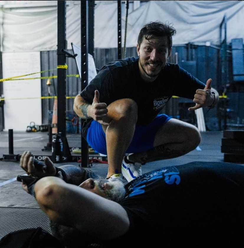 Brian Yepez coaching a client through floor exercises at the gym